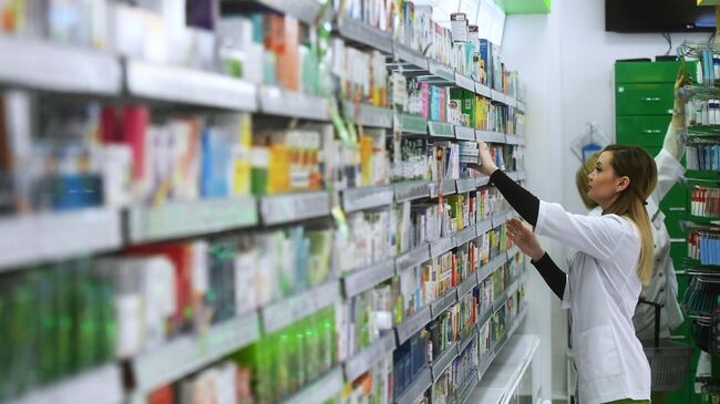 Фармацевт в аптеке раскладывает лекарственные препараты