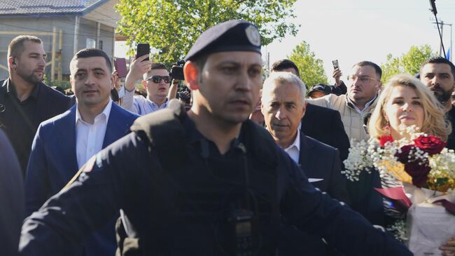 Кандидат в президенты Джордже Симион покидает избирательный участок после голосования во втором туре повторных президентских выборов в Могошоае