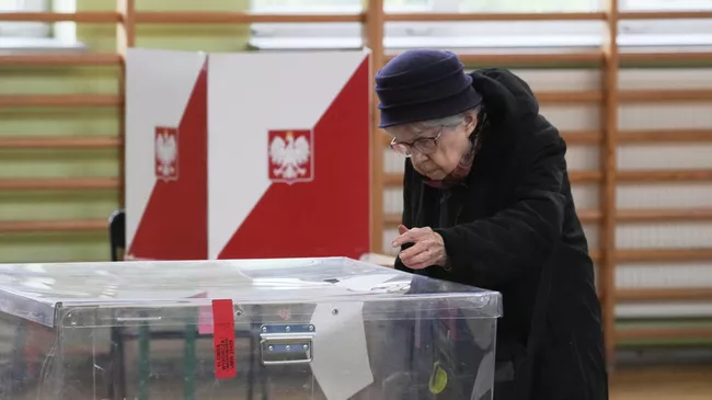 Женщина голосует в первом туре президентских выборов на избирательном участке в Варшаве, Польше