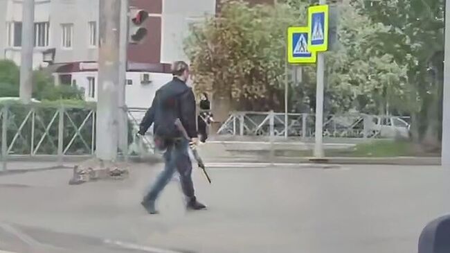 Мужчина с предметом, похожим на ружье, в Перми. Кадр видео из соцсетей Мужчина с предметом, похожим на ружье, в Перми. Кадр видео из соцсетей