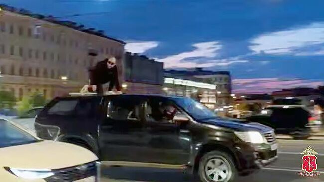 Мужчина на крыше автомобиля в Санкт-Петербурге. Кадр видео