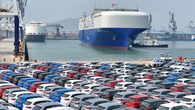 Новые китайские автомобили ожидают погрузку на корабль в поту Яньтая, Китай