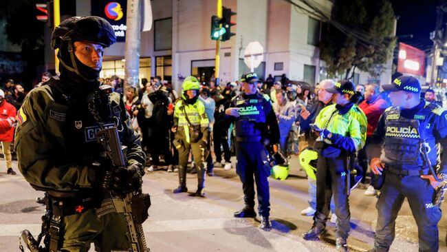 Полиция перед зданием больницы, куда доставили сенатора Мигеля Урибе после нападения