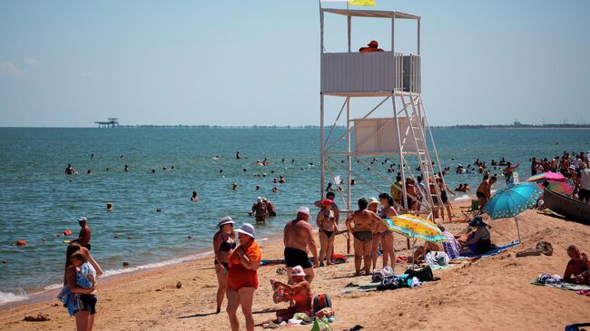 Отдыхающие на пляже в станице Голубицкой в поселке в Краснодарском крае Отдыхающие на пляже в станице Голубицкой в поселке в Краснодарском крае