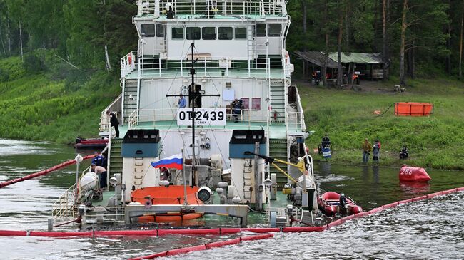 Специалисты огораживают бонными заграждениями и откачивают выливающееся в реку дизельное топливо из потерпевшего крушение буксира-толкача ОТ-2439 Обь-Иртышского речного пароходства на Енисее