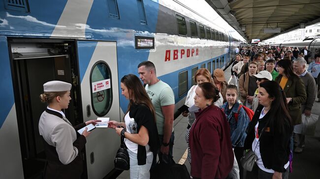 Пассажиры садятся в скоростной двухэтажный поезд Аврора (Москва - Санкт-Петербург) на Ленинградском вокзале в Москве