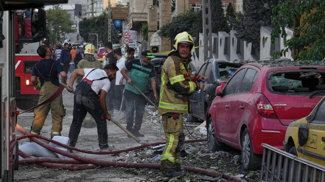 Пожарные работают на месте взрыва в Тегеране после ударов Израиля по Ирану