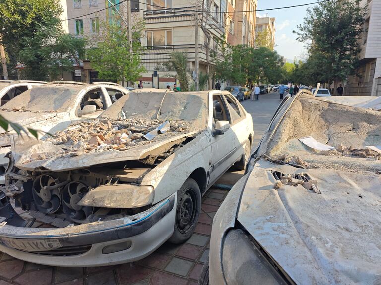Поврежденные автомобили на площади в районе Нармак в Тегеране после израильских авиаударов Поврежденные автомобили на площади в районе Нармак в Тегеране после израильских авиаударов