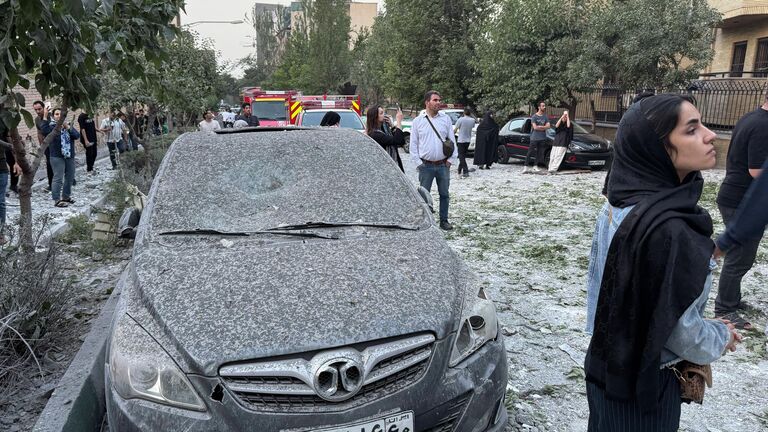 Mensen inspecteren de nasleep van een enorme Israëlische luchtaanval in Teheran