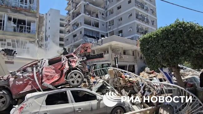 Разбор завалов на месте попадания иранской ракеты