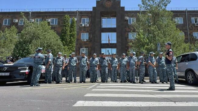 Полицейские стоят в оцеплении возле здания суда в Ереване, куда был доставлен российский предприниматель, президент группы компаний Ташир Самвел Карапетян