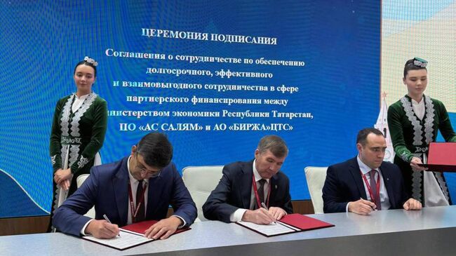 Вице-премьер Татарстана - министр экономики Мидхат Шагиахметов, генеральный директор АО Биржа ЦТС Виталий Хайрулин и председатель правления потребительского общества АС Салям Ренат Едиханов на церемонии подписания
