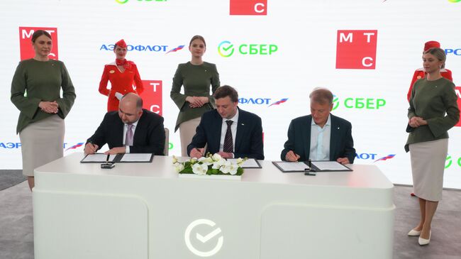 Генеральный директор Экосистема МТС Ровшан Алиев, генеральный директор ПАО Аэрофлот Сергей Александровский, председатель правления ПАО Сбербанк Герман Греф во время подписания соглашения о намерении Развитие стратегического сотрудничества на ПМЭФ-2025