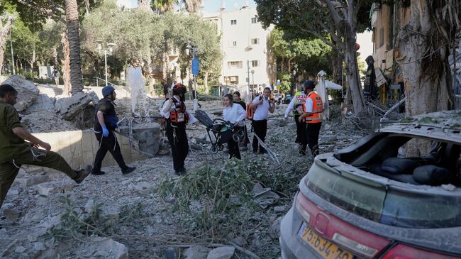 Спасатели и пожарные на месте ракетного удара Ирана в Хайфе, Израиль