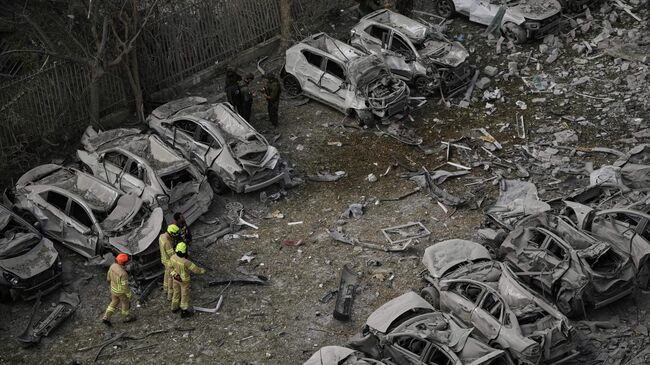 Пожарные осматривают место иранского ракетного удара в Израиле