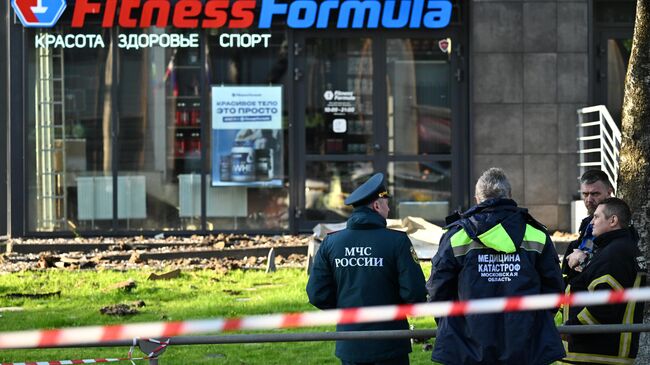 Сотрудники МЧС России и Мособлпожспаса у жилого дома, в который попал БПЛА, в подмосковном Красногорске