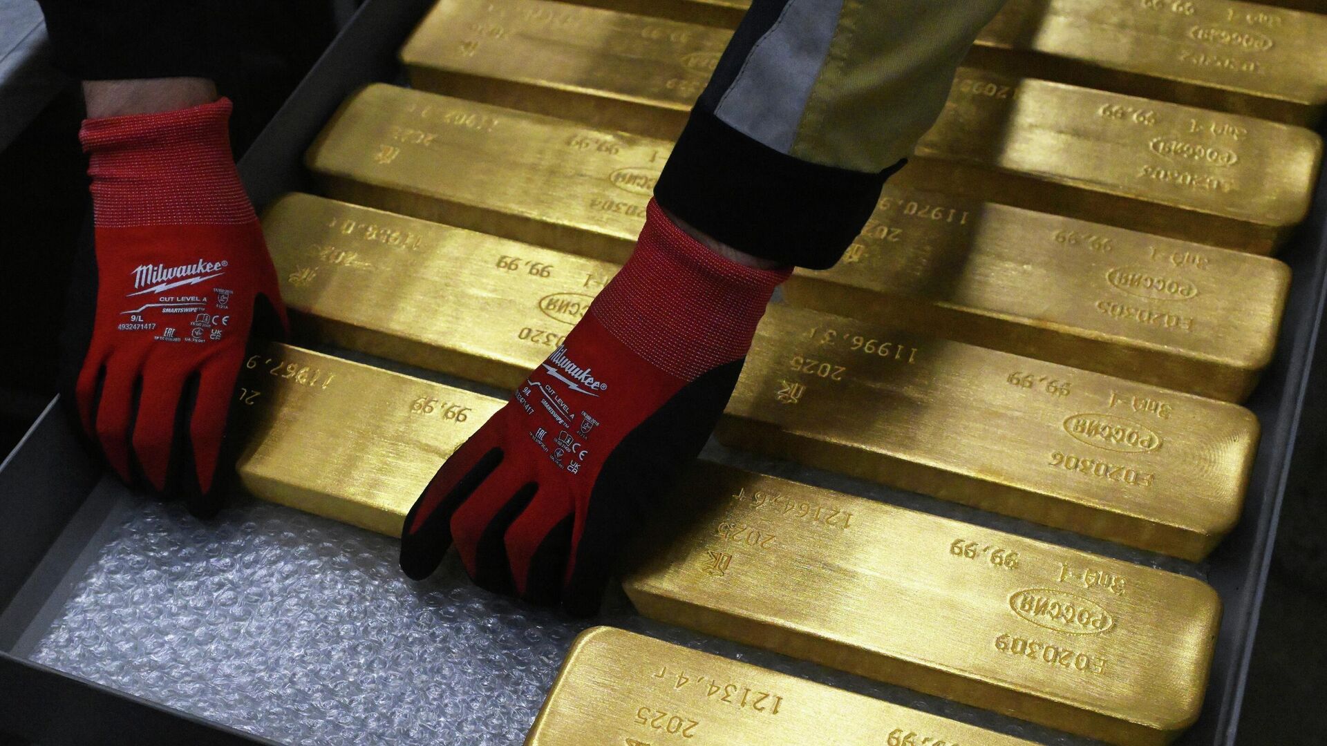 Сотрудник складывает на тележку готовые маркированные слитки золота высшей пробы - РИА Новости, 1920, 20.12.2025