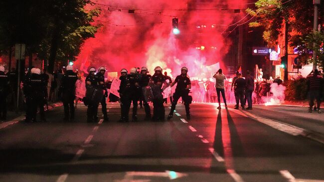 Полицейские блокируют улицу во время акции протеста в Белграде