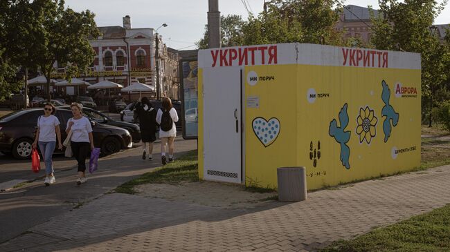 Жители города проходят мимо укрытия в Сумах, Украина