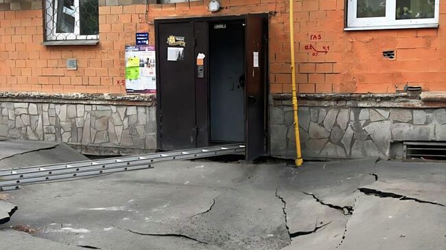Место просадки грунта под стеной подъезда пятиэтажного дома в Красноярске