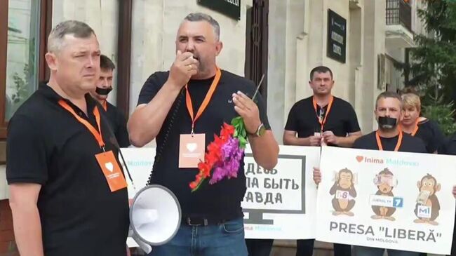 Оппозиционная молдавская партия Сердце Молдовы проводит акцию против цензуры у здания Совета по телевидению и радио. Кадр видео
