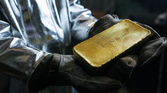 Слиток золота в руках рабочего