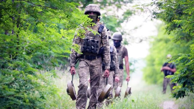 Украинские военные несут противотанковые мины