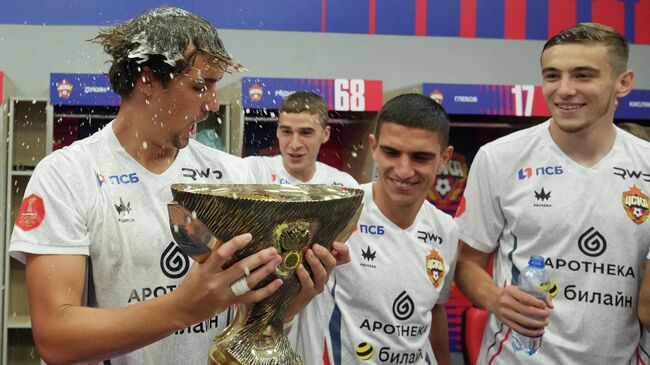 Матвей Лукин (ЦСКА) с кубком празднует в раздевалке победу в матче Суперкубка России 2025 по футболу в Казани.