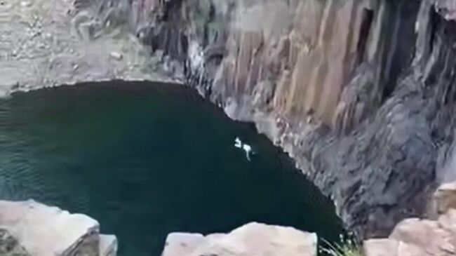 В Норильске мужчина прыгнул со скалы в ущелье Красные камни. Кадр видео из соцсетей В Норильске мужчина прыгнул со скалы в ущелье Красные камни. Кадр видео из соцсетей