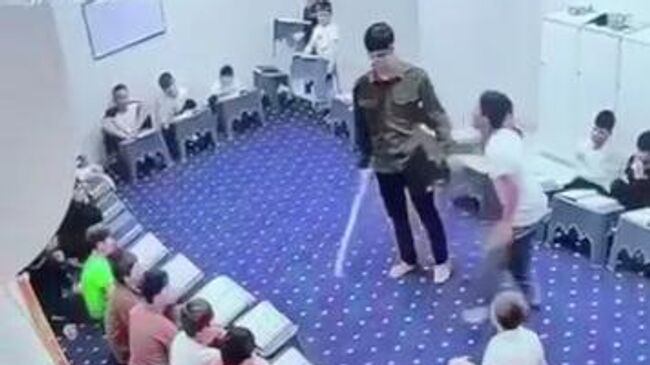 Кадр видео, на котором учитель школы в г. Гудермес наносит удары палкой двум несовершеннолетним ученикам