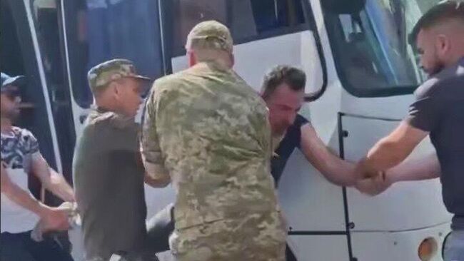 Сотрудники ТЦК Украины заталкивают мужчину в автобус
