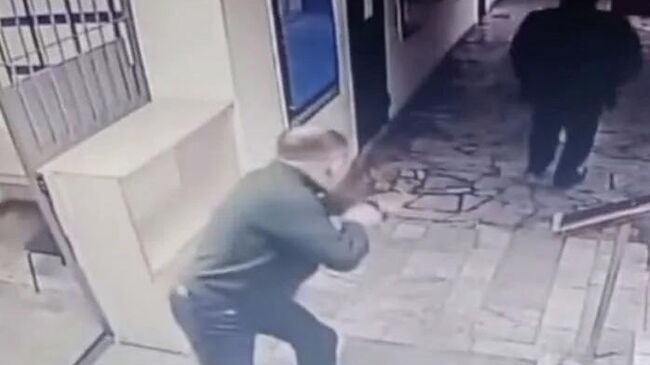 Кадр видео с камеры наблюдения, на котором начальник отдела полиции Абайской области бегает за своими подчиненными и стреляет в них из рогатки