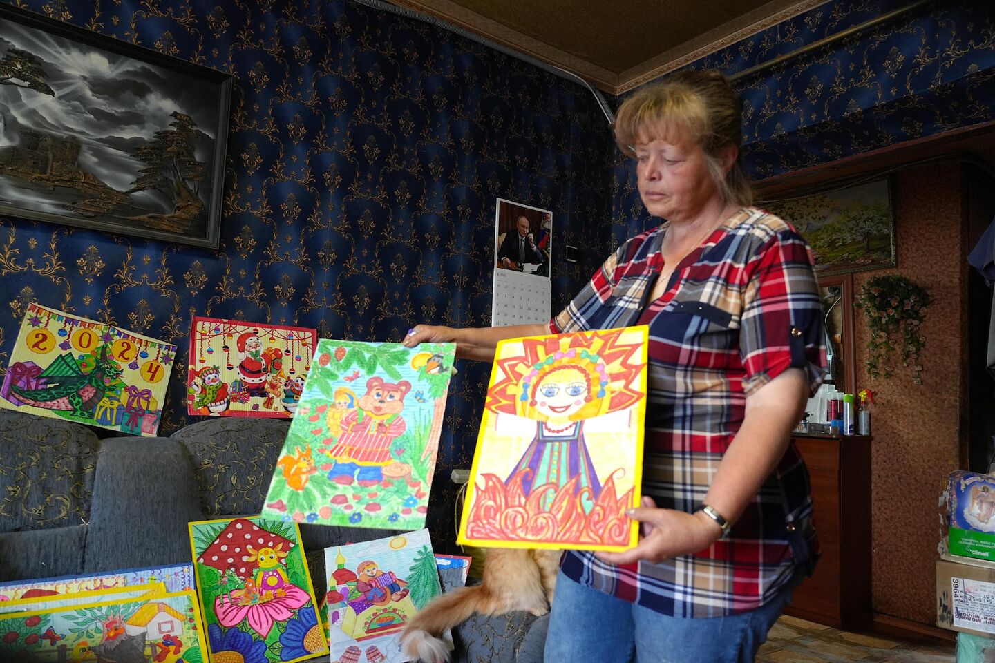 Людмила Николаевна показывает картины, которые рисовала в подвале, укрываясь от обстрелов Людмила Николаевна показывает картины, которые рисовала в подвале, укрываясь от обстрелов