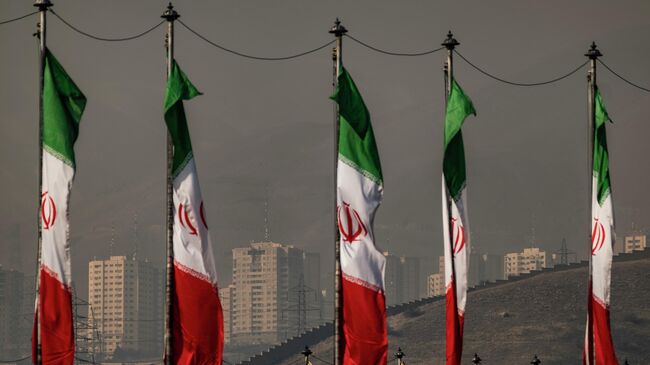 Иранские флаги на фоне Тегерана