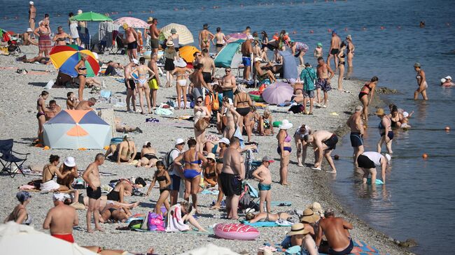 Люди во время отдыха на пляже в Геленджике