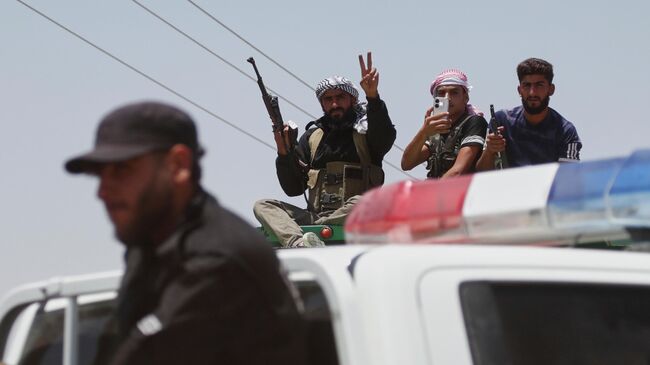 Сотрудник сил внутренней безопасности Сирии на фоне бедуинских солдат