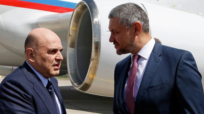 Председатель правительства РФ Михаил Мишустин и губернатор Забайкальского края Александр Осипов во время церемонии встречи в аэропорту Кадала в Чите. 22 июля 2025