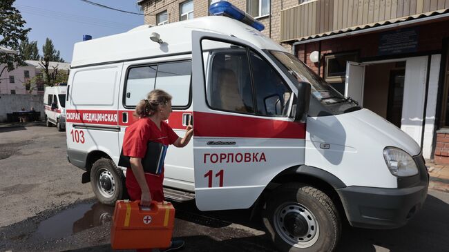 Медик мобильной бригады готовится к выезду в автомобиле скорой помощи в Горловке