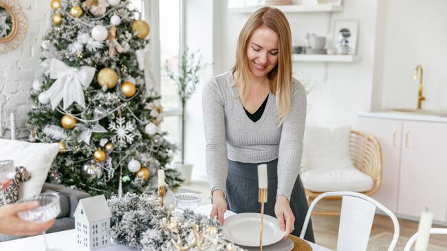 Девушка накрывает праздничный стол 