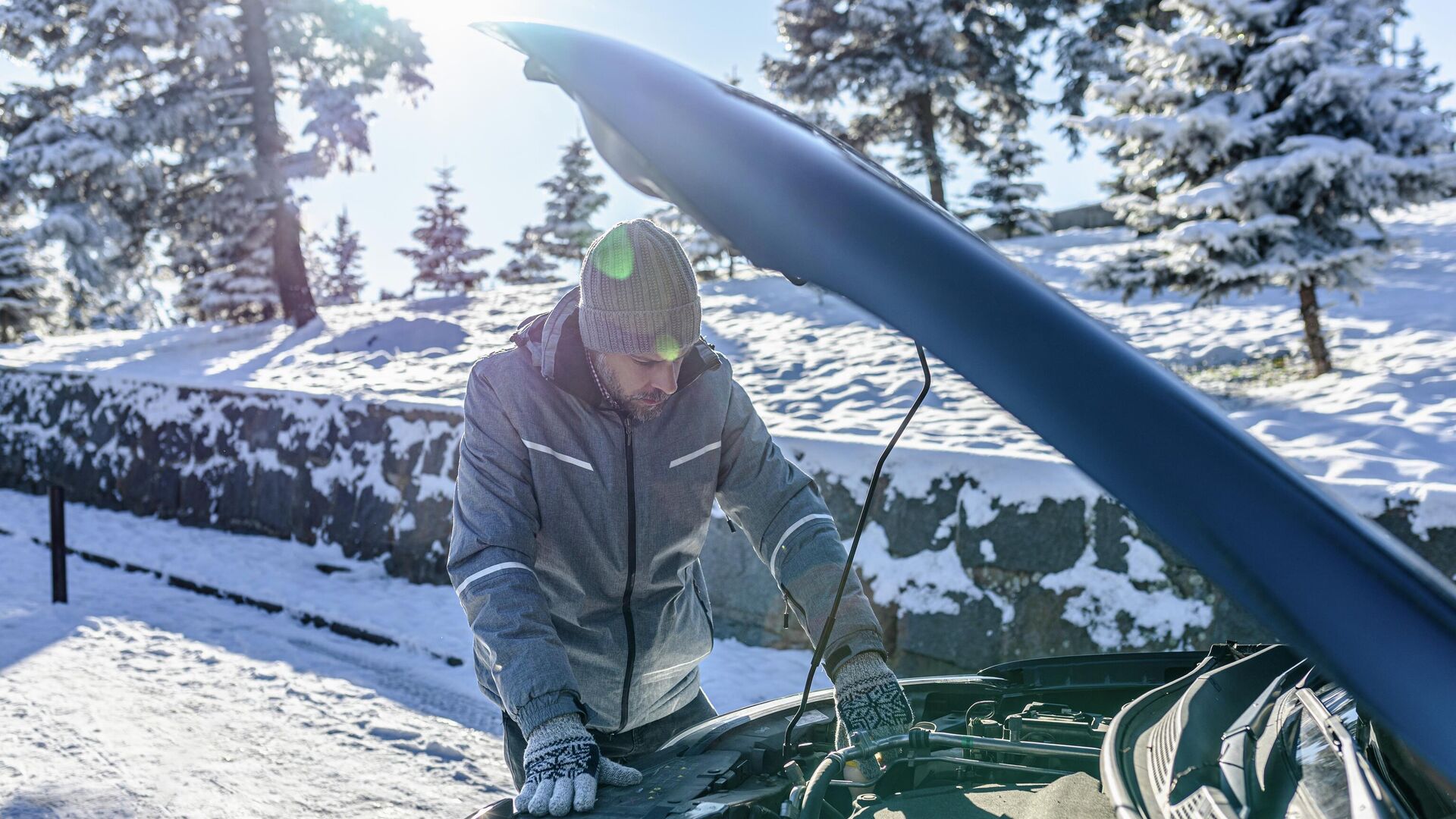 Мужчина смотрит в капот автомобиля зимой Мужчина смотрит в капот автомобиля зимой - РИА Новости, 1920, 09.12.2021