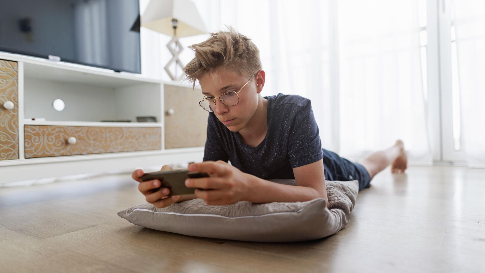 Подросток играет в смартфон Подросток играет в смартфон - РИА Новости, 1920, 20.07.2024