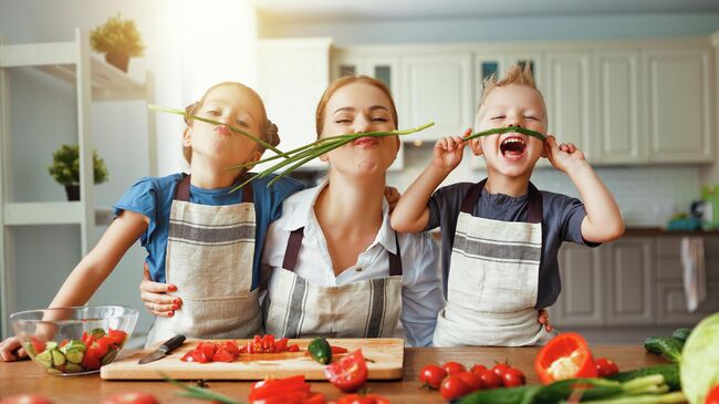 Женщина с детьми готовит салат