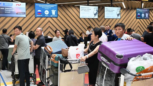 Пассажиры у стоек регистрации в международном аэропорту Шереметьево
