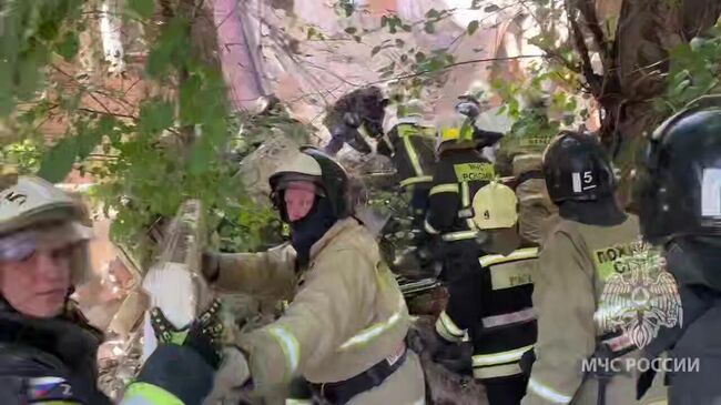 Сотрудники МЧС РФ на месте обрушения части подъезда пятиэтажного дома на улице Ляхова в Астрахани. Стоп-кадр видео Сотрудники МЧС РФ на месте обрушения части подъезда пятиэтажного дома на улице Ляхова в Астрахани. Стоп-кадр видео