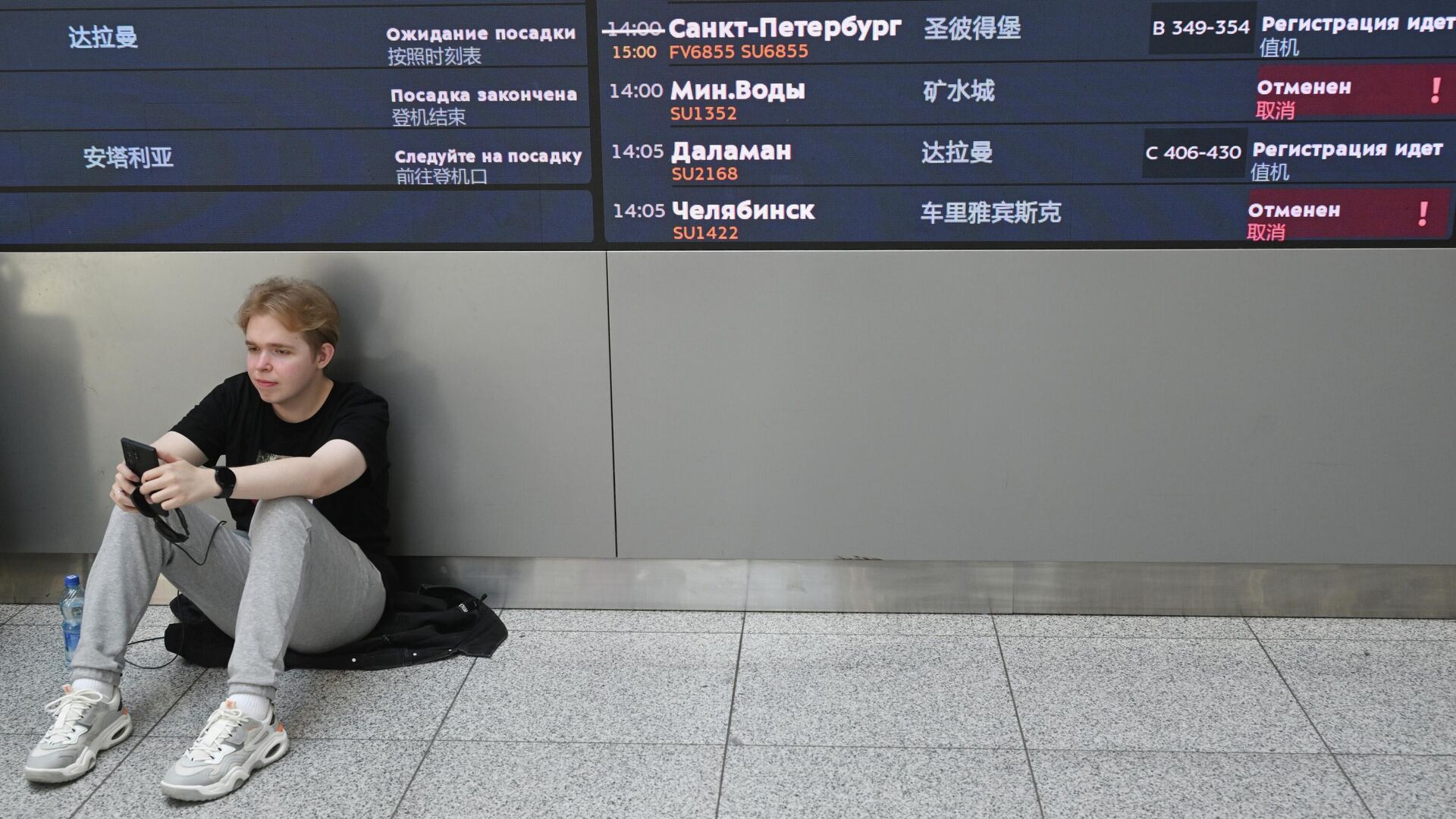 Молодой человек у табло вылета в Международном аэропорту Шереметьево имени А.С. Пушкина - РИА Новости, 1920, 12.12.2025