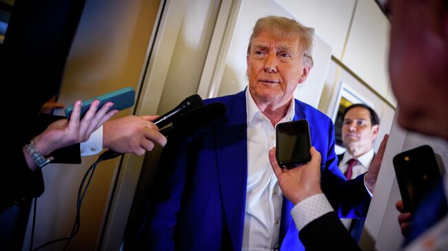 Президент США Дональд Трамп во время беседы с журналистами на борту президентского самолета