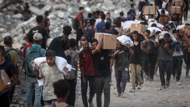 Палестинцы в пункте раздачи гуманитарной помощи возле пограничного перехода Зиким
