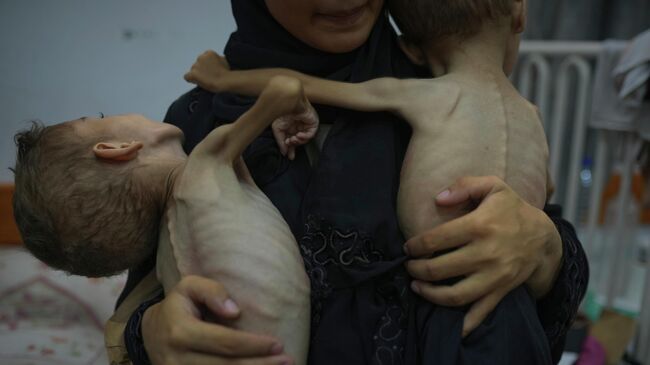Женщина с сыновьями, страдающими от недоедания, в одной из больниц в Газе Женщина с сыновьями, страдающими от недоедания, в одной из больниц в Газе