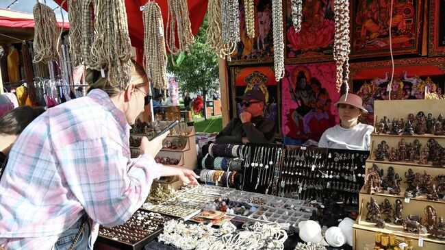 Посетительница выбирает украшения на 10-м фестивале День Индии в Южном ландшафтном парке Остров Мечты в Москве