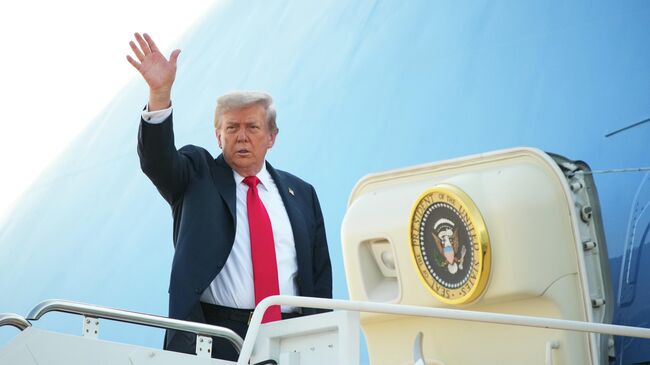 Президент США Дональд Трамп поднимается на борт перед вылетом на Аляску